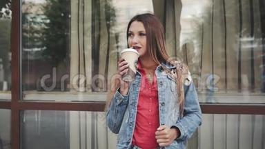 穿着红色衬衫和长袖夹克的女人站着喝咖啡。